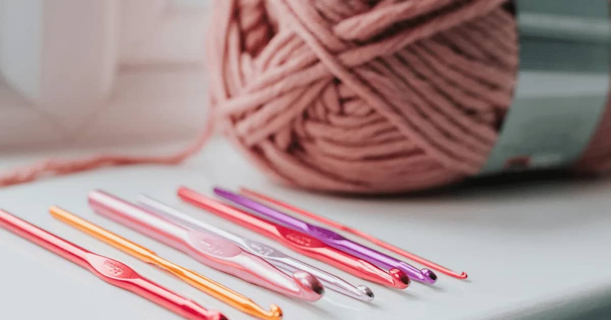 Colorful crochet hooks and yarn ball for knitting, a popular hobby among women in their 30s with kids and those interested in relaxing activities.