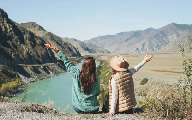 two women enjoying a mountain view, a perfect outdoor hobby for women in their 20s.