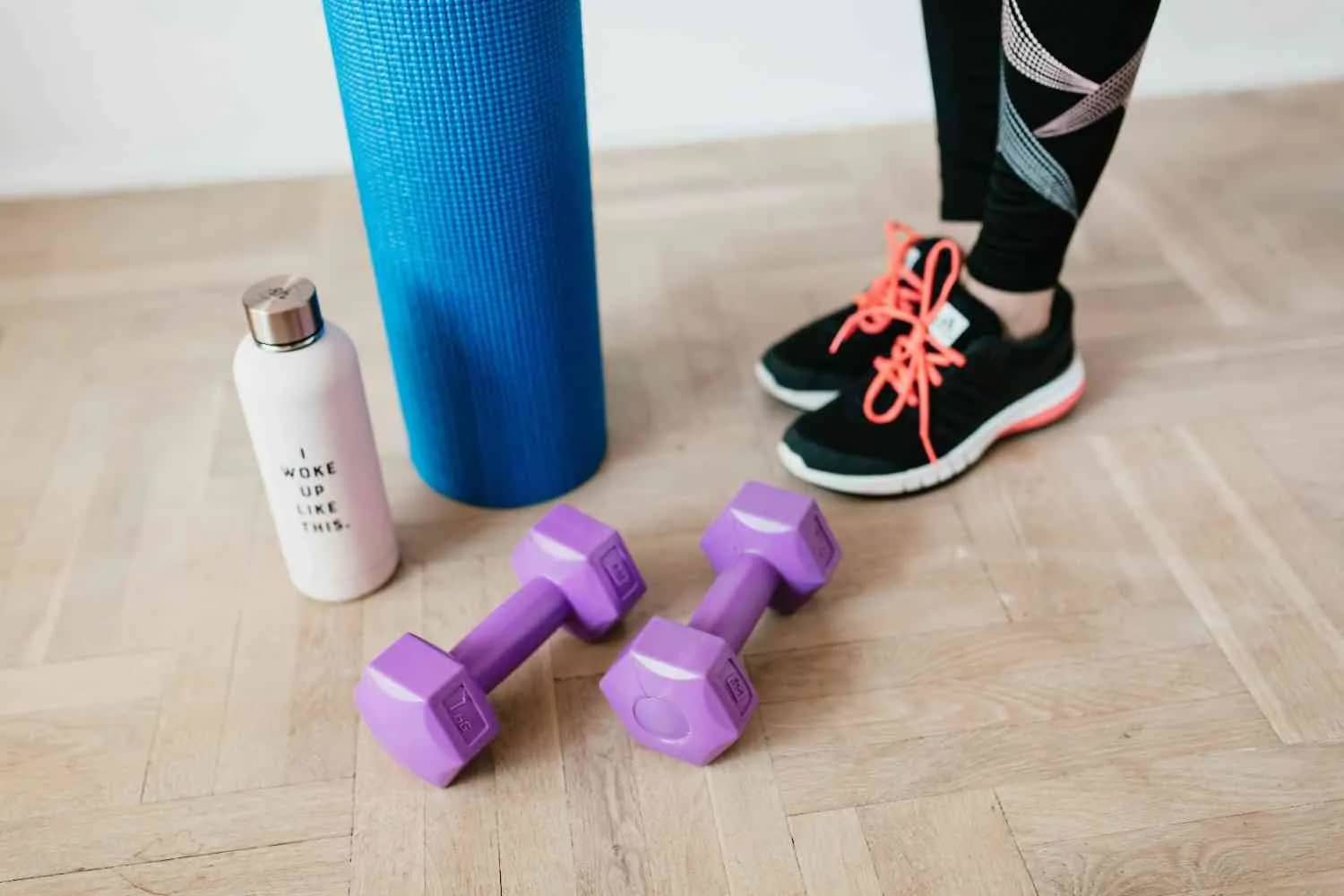 Dumbbells, a water bottle, and a yoga mat, suggesting a fitness and exercise routine.